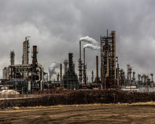 Photo by Patrick Hendry factories with smoke under cloudy sky